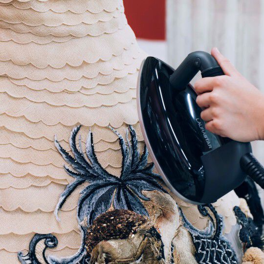 
                Chinese designer Guo Pei using a Laurastar iron on one of her designs at Paris Fashion Week.
                